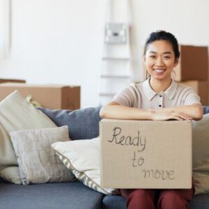 Woman holding a box with "Ready to Move" written on it